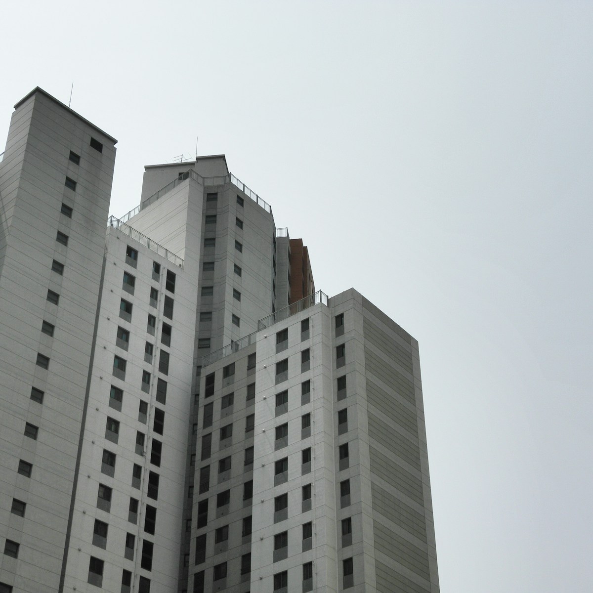 Tall apartment buildings against a gray sky.