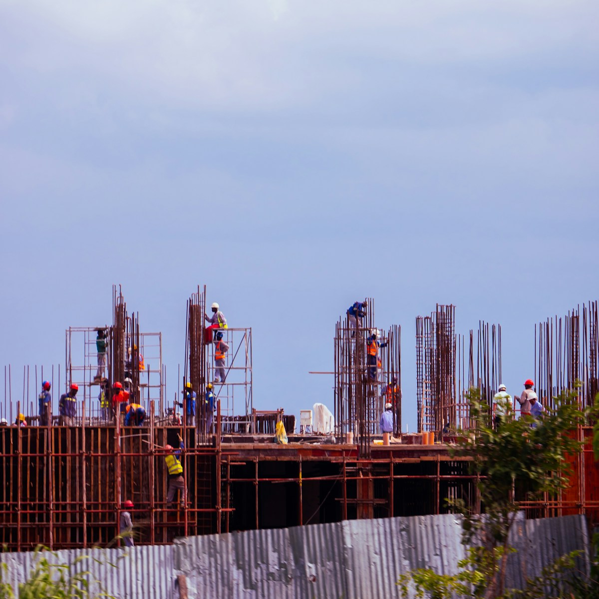 A group of people standing on top of a building under construction